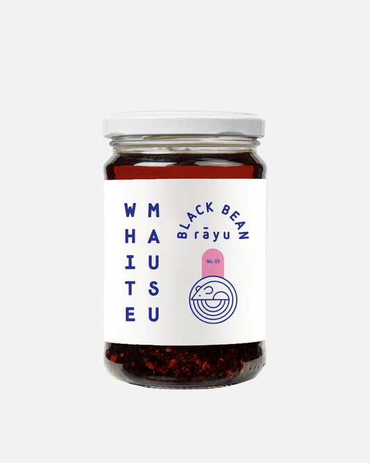 Ein Glas mit Black Bean Rayu Chili Öl von White mausu - eine scharfe Chilisauce mit schwarzen Bohnen und Gewürzen.