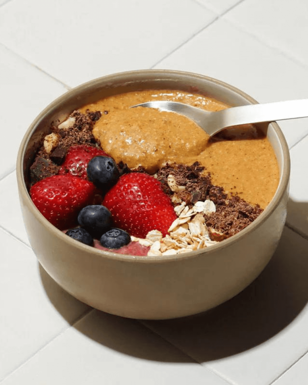Eine Schale mit leckerem Granola, Cravers Nussbutter und Beeren.