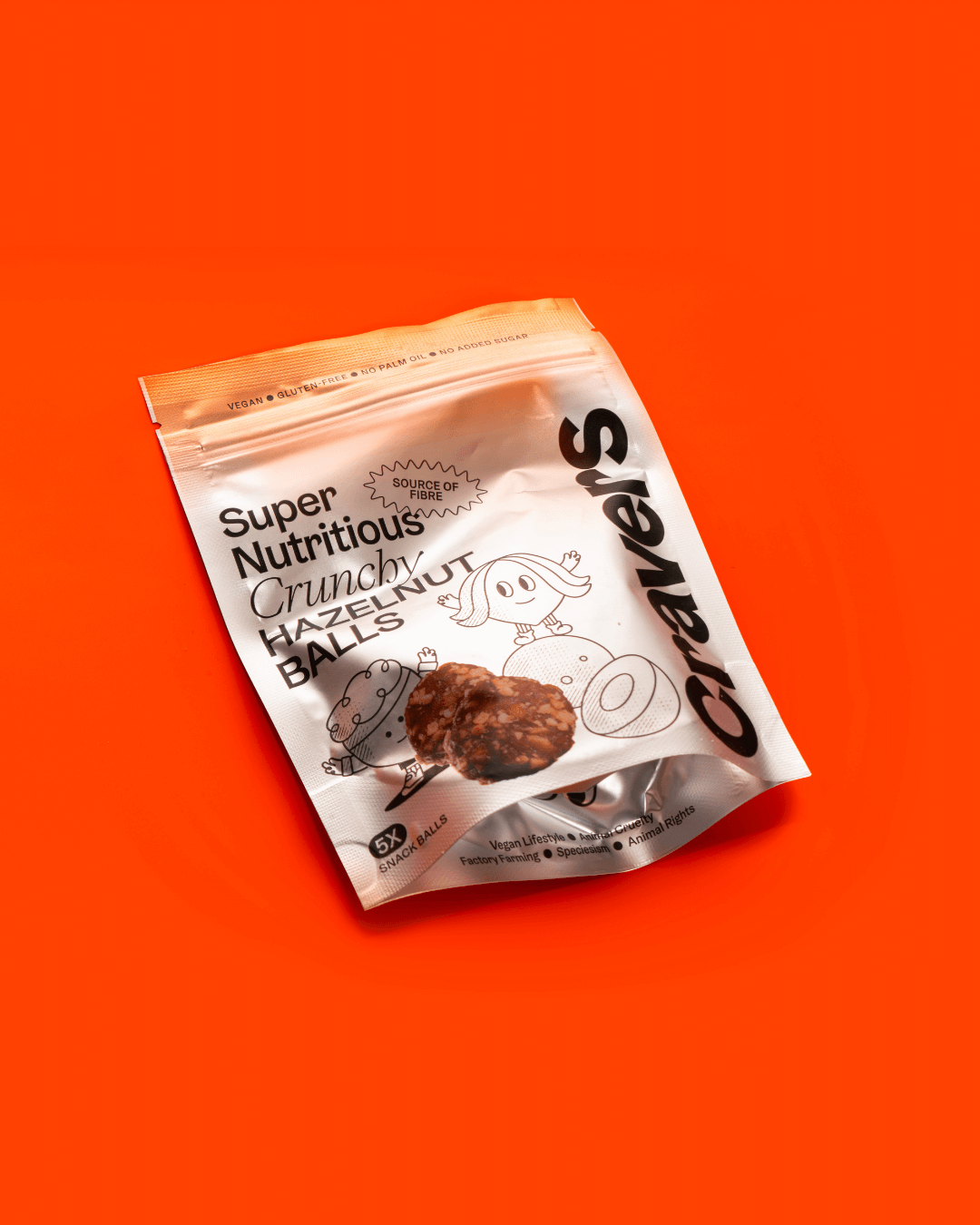 Verpackung von Cravers Super Nutritious Crunchy Hazelnut Balls auf einem orangen Hintergrund.