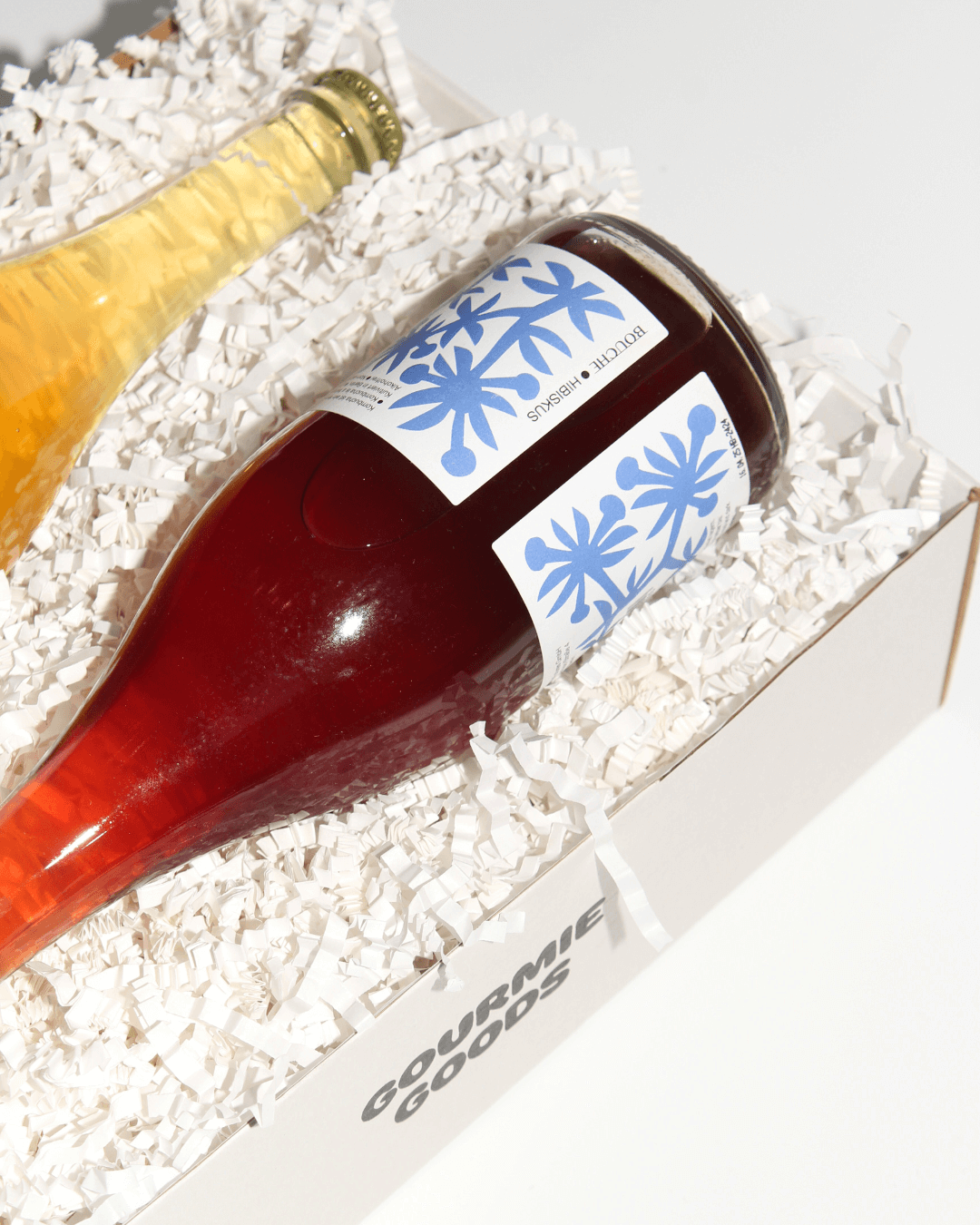Eine Flasche Bouche Hibiskus Pet Nat in einer weißen Geschenkbox von Gourmie Goods.