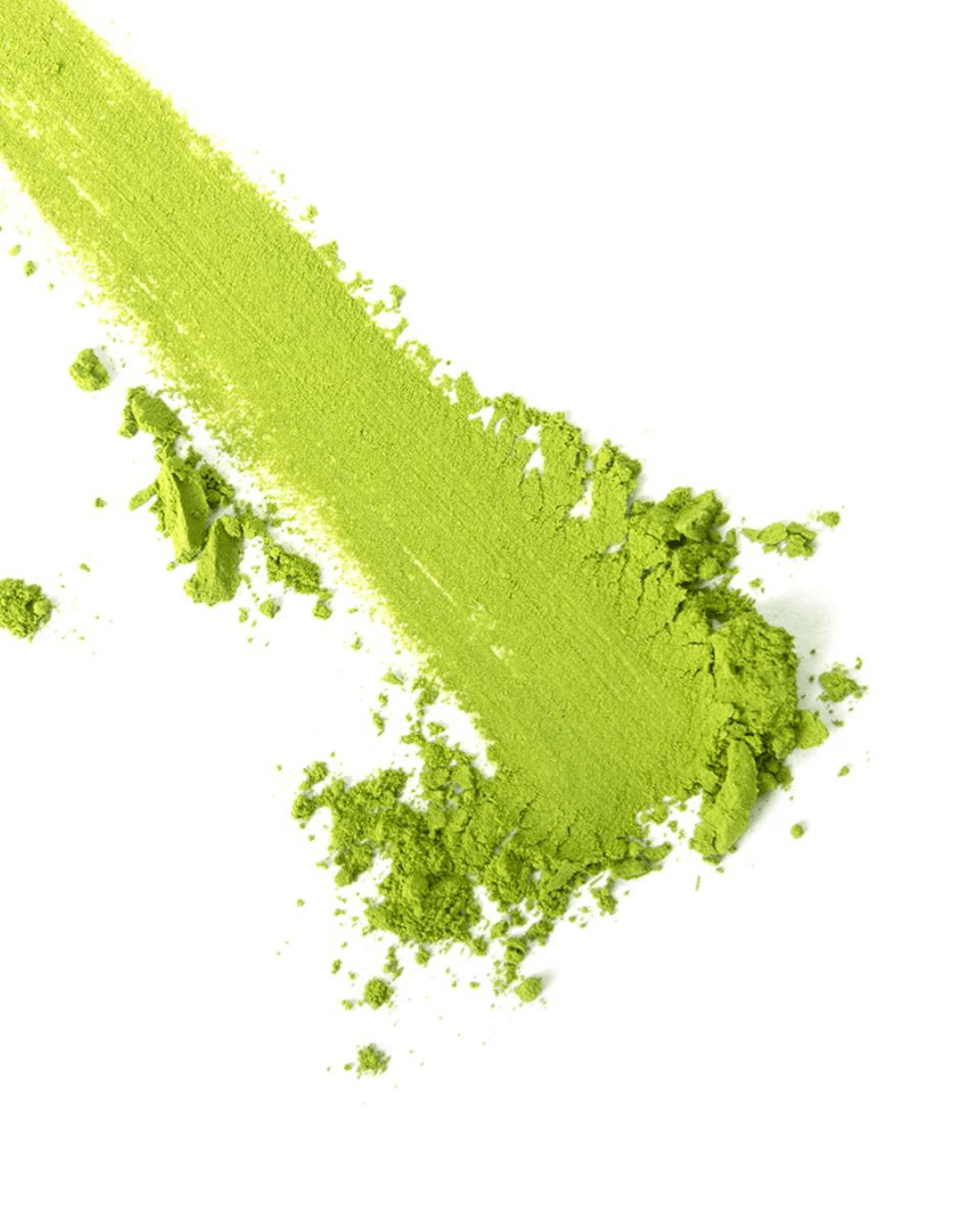 Grünes Matcha-Pulver von Matchasome, verstreut auf weißem Hintergrund, zeigt die feine Textur des Matcha.