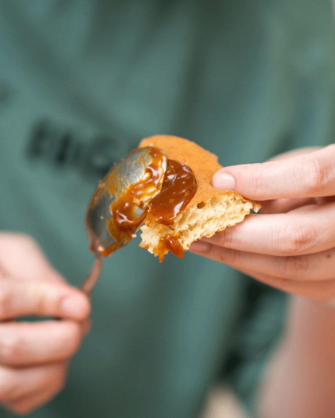 Person streicht gesalzenen Bio-Karamellaufstrich auf ein Stück Brioche.