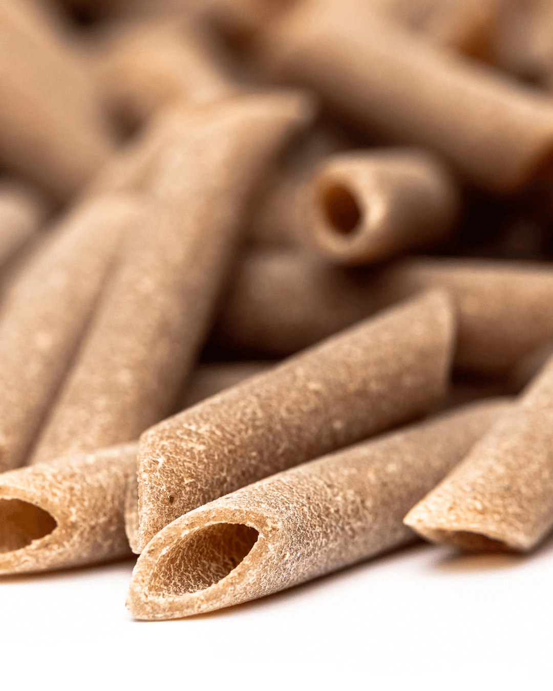 Makroaufnahme der Bio Penne Lisce Turanici von Mancini mit glatter Oberfläche und natürlicher, dunkler Farbe aus italienischem Urweizen.