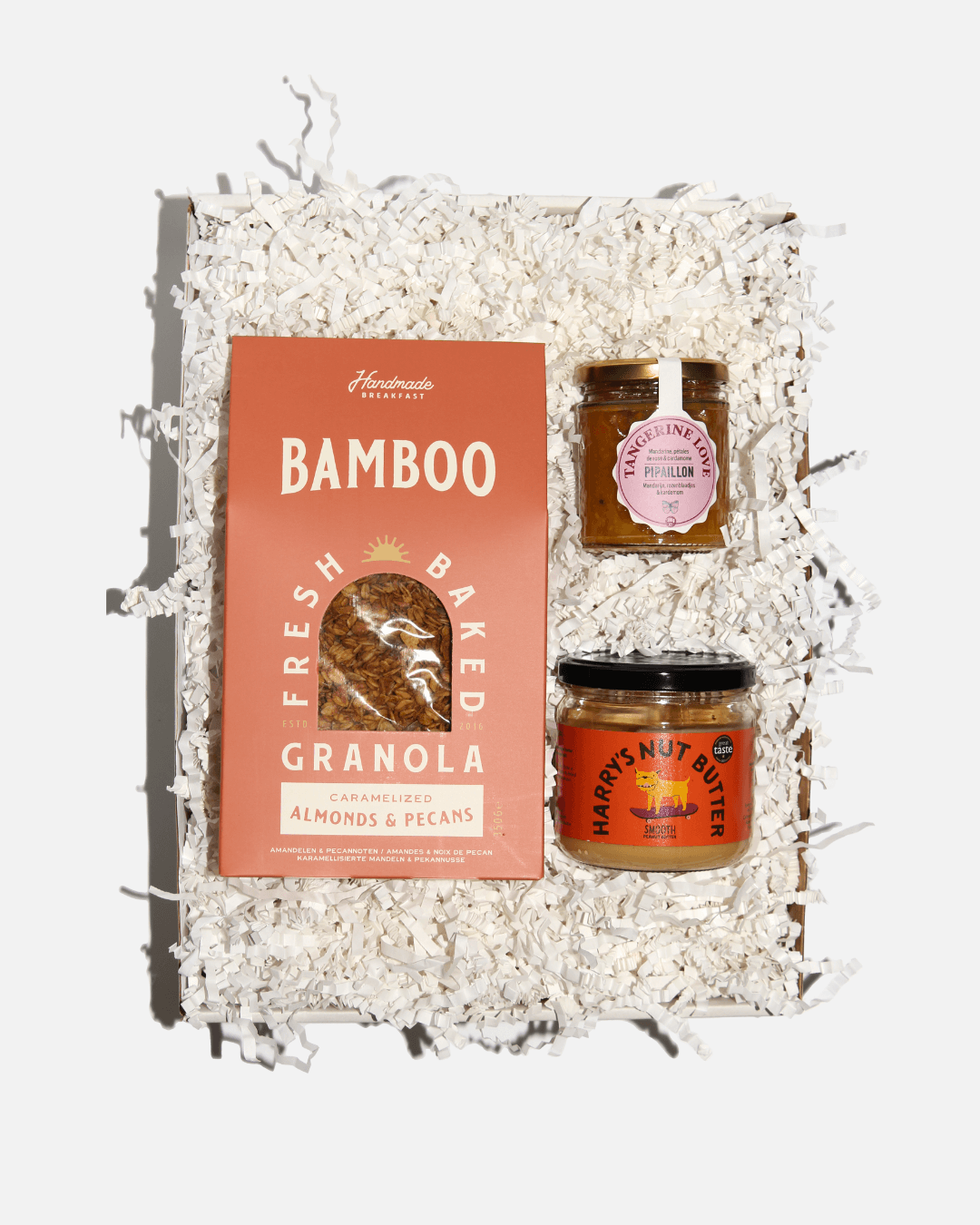 Weiße Geschenkbox „Breakfast in Bed“ mit Granola von Bamboo, Marmelade von Pipaillon, Erdnussbutter von Harry's Nut Butter.