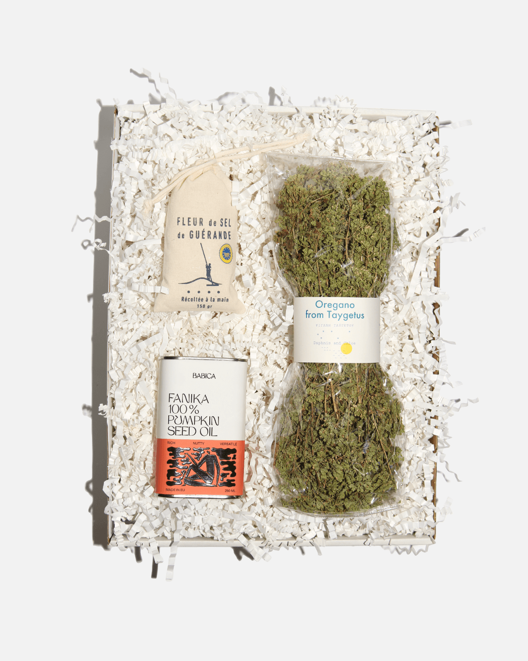 Weiße Geschenkbox „Chef’s Secret Stash“ mit Fleur de Sel de Guérande, Oregano vom Taygetos-Gebirge und Fanika Kürbiskernöl.