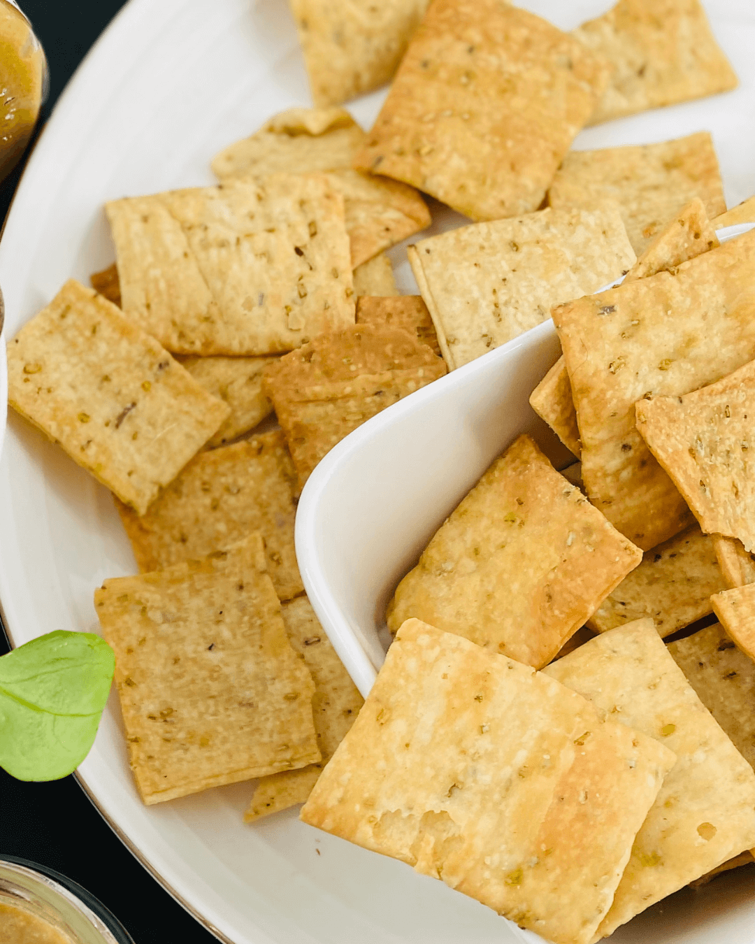 Knusprige Cracker mit Rosmarin auf weißem Teller, serviert in Schale