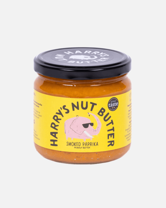 Glas Harry's Erdnussbutter mit geräuchertem Paprika, gelbes Etikett und schwarzer Deckel, vor weißem Hintergrund.