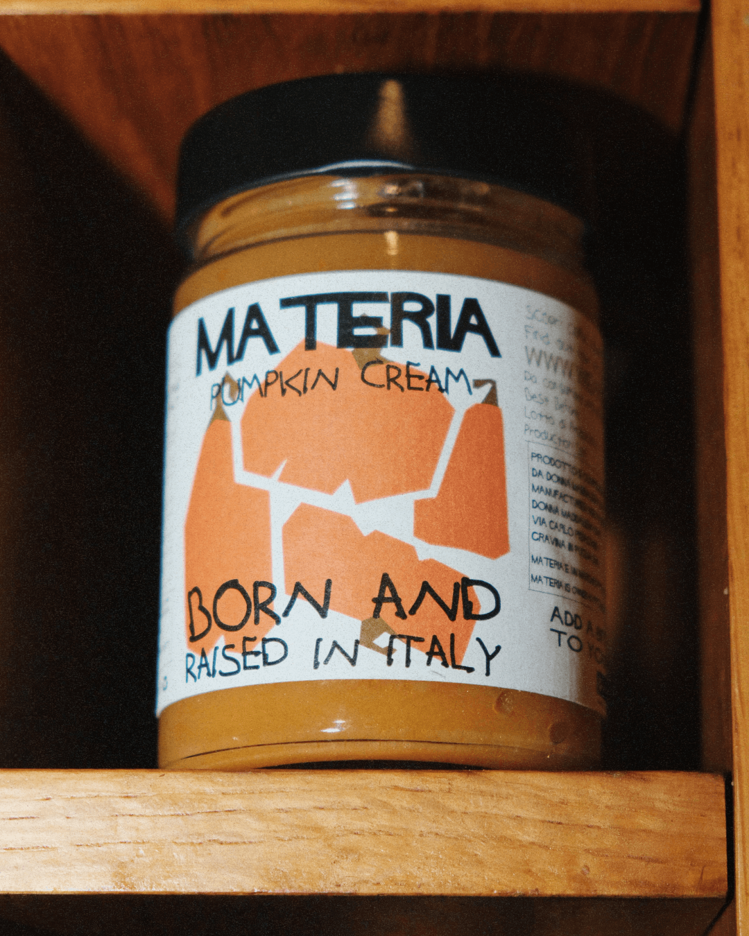 Glas Materia Kürbiscreme mit auffälligem Etikett, gelagert in einem Holzregal.