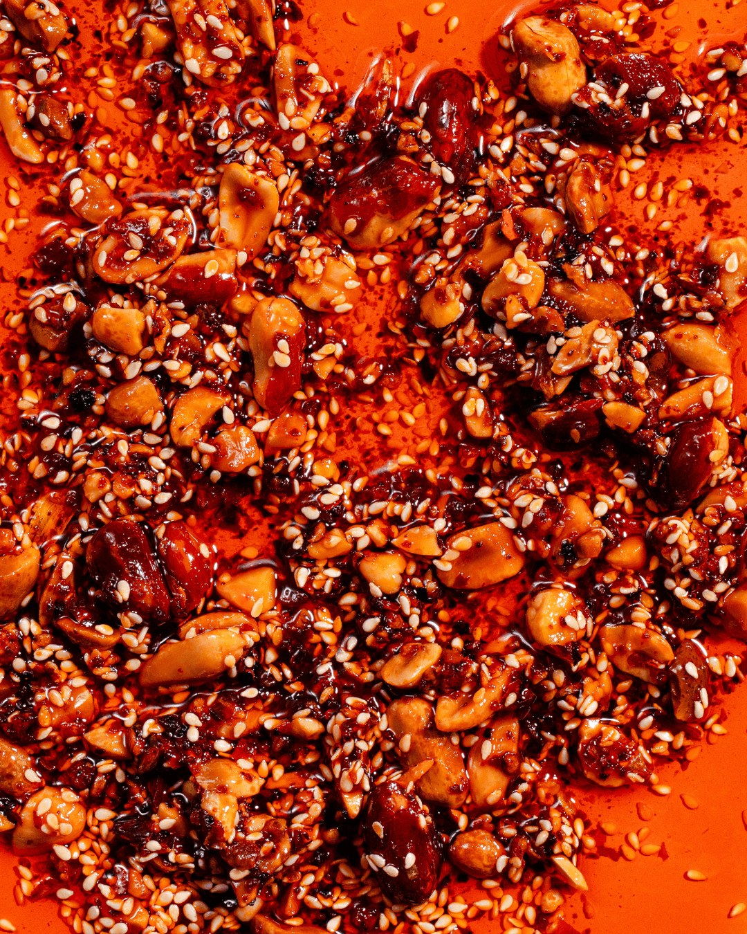 Nahaufnahme der White Mausu Peanut Rayu mit gerösteten Erdnüssen, Sesam und Chiliöl in goldroter, knuspriger Textur.