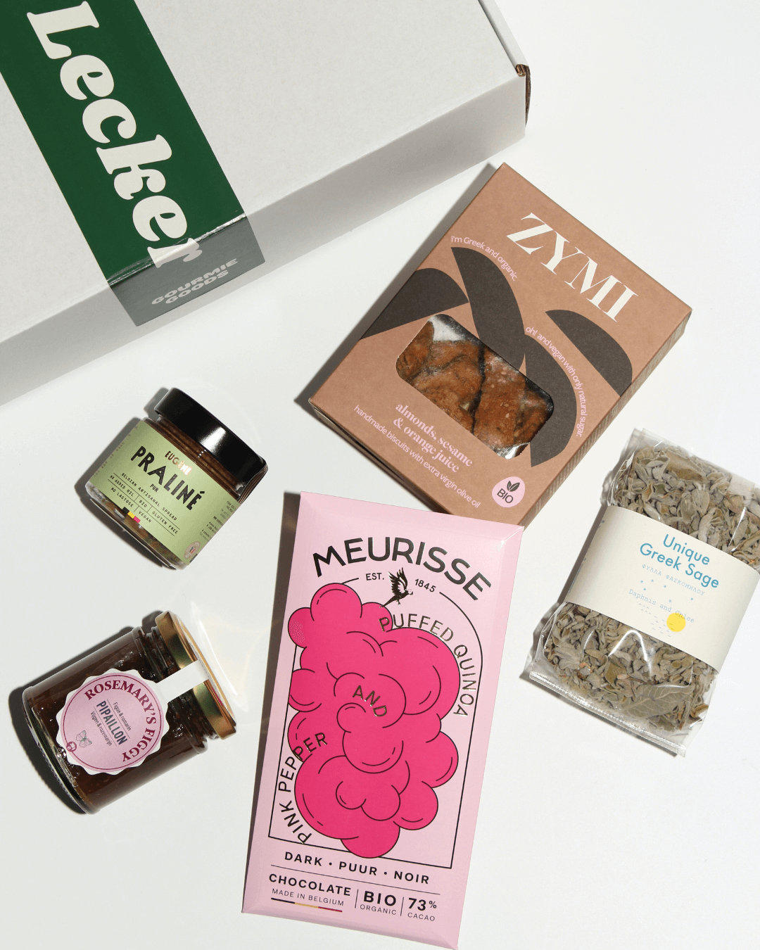 Ein Geschenkset mit Meurisse Bio-Dunkelschokolade, ZYMI Keksen, Pipaillon Marmelade, Eugene Bio-Praline, griechischem Salbei.