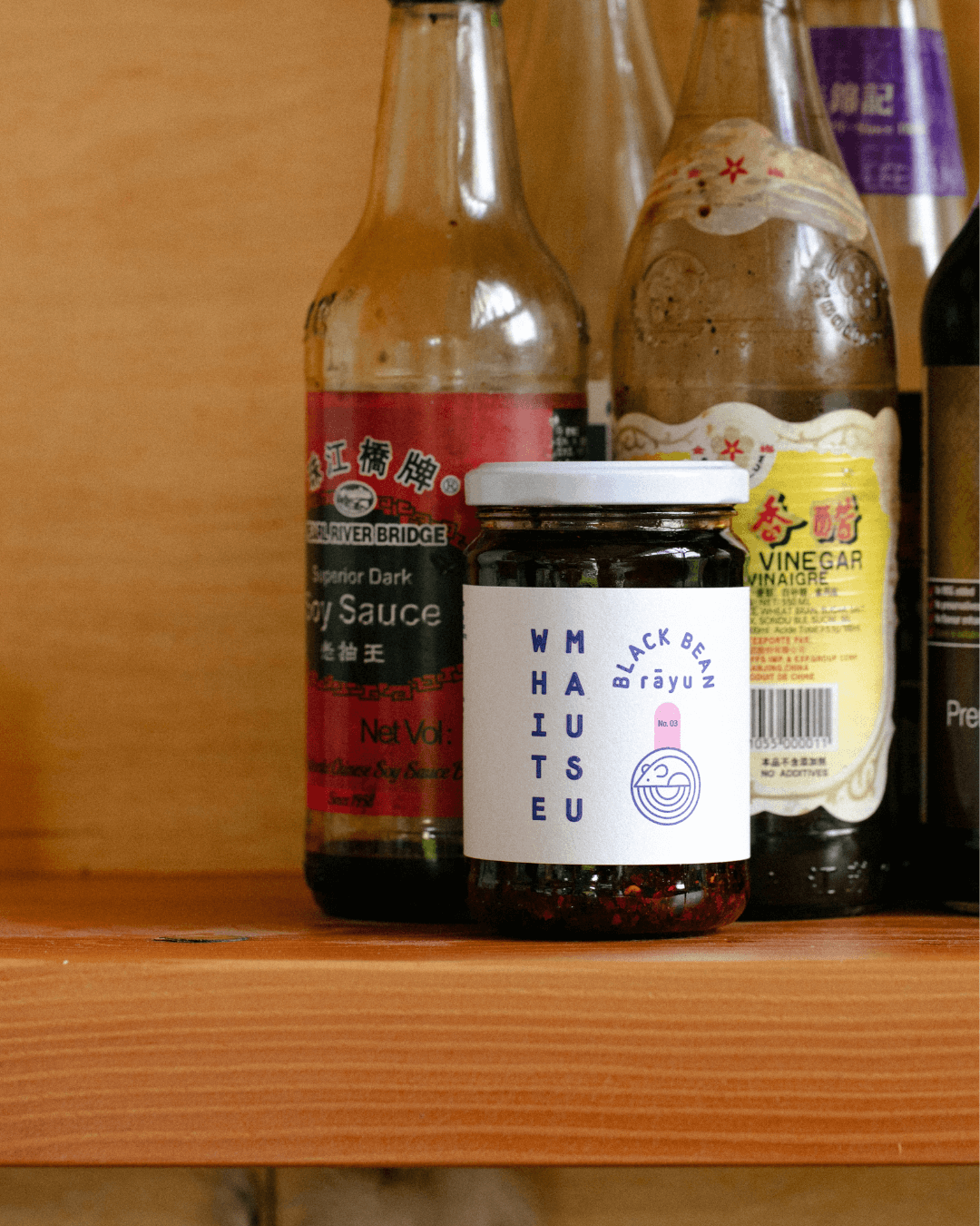 White Mausu Black Bean Rayu im Regal mit Sojasauce und Essig.