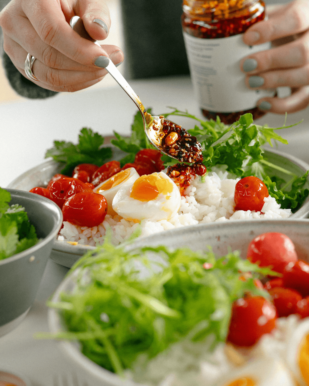Reisschüssel mit Ei, Tomaten und einem Löffel White Mausu.