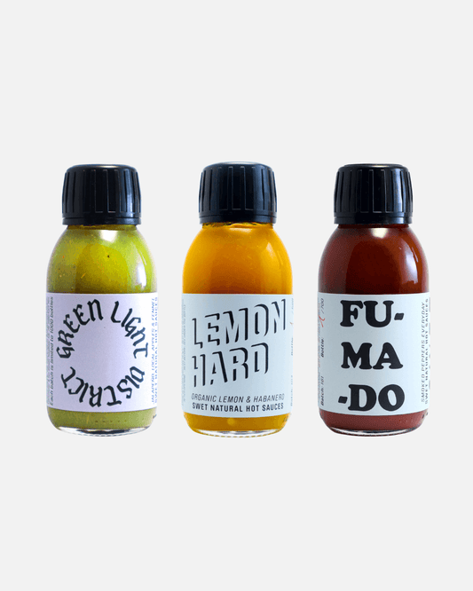 Drei Flaschen SWET Hot Sauce: Green Light District (grün), Lemon Hard (gelb) & Fumado (rot).