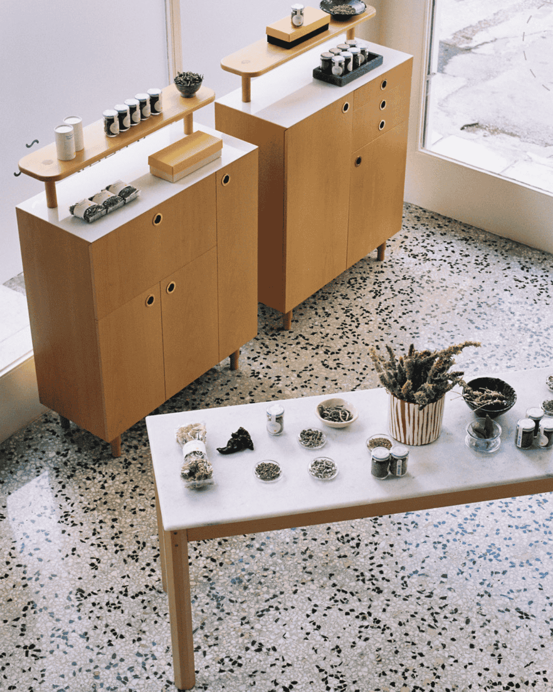 Das Daphnis and Chloe Studio in Athen mit minimalistischer Holz- und Marmoreinrichtung, präsentiert erlesene Kräuter.